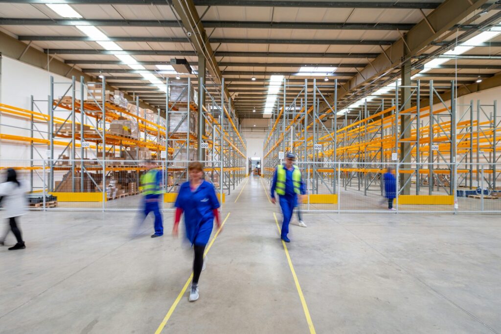 Staff in hi-vis workwear walking through a warehouse